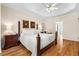 Bright bedroom with hardwood floors, four-poster bed, and tray ceiling, creating a luxurious retreat at 1012 Chestnut Creek Dr, Villa Rica, GA 30180