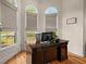 Bright home office with a large desk, hardwood floors, and charming arched windows at 1012 Chestnut Creek Dr, Villa Rica, GA 30180