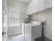 Functional laundry room with white appliances, custom cabinetry, and stylish tile flooring at 1012 Chestnut Creek Dr, Villa Rica, GA 30180