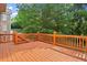 Spacious wooden back deck with wood railings surrounded by mature trees at 10565 Highgate Manor Ct, Duluth, GA 30097