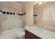 Bathroom featuring a tub, tiled shower, and single sink vanity with stone countertop at 10565 Highgate Manor Ct, Duluth, GA 30097