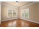 Sunny bedroom with hardwood floors, crown molding and large windows overlooking yard at 10565 Highgate Manor Ct, Duluth, GA 30097