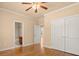 Bedroom with hardwood floors, ceiling fan, and ensuite bathroom access at 10565 Highgate Manor Ct, Duluth, GA 30097