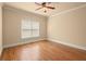 Cozy bedroom with hardwood floors, a ceiling fan, and a window allowing natural light at 10565 Highgate Manor Ct, Duluth, GA 30097