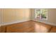 Bedroom with wood floors, trim, and a window providing natural light at 10565 Highgate Manor Ct, Duluth, GA 30097
