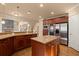 An open-concept kitchen boasts stainless steel appliances, a center island, and custom cabinetry at 10565 Highgate Manor Ct, Duluth, GA 30097