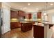 A gourmet kitchen features custom wood cabinets, an island, and stainless steel appliances at 10565 Highgate Manor Ct, Duluth, GA 30097
