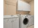 Laundry room complete with washer, dryer, utility sink, and upper cabinets at 10565 Highgate Manor Ct, Duluth, GA 30097