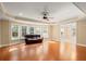 Spacious living room with hardwood floors, large windows, and stylish ceiling fan at 10565 Highgate Manor Ct, Duluth, GA 30097