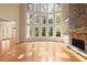 Bright and sunny living room featuring a stone fireplace and large windows at 10565 Highgate Manor Ct, Duluth, GA 30097