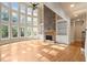 Bright living room featuring large windows, tall ceilings, a stone fireplace, and built-in bookshelves at 10565 Highgate Manor Ct, Duluth, GA 30097