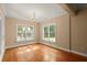 Room with gleaming hardwood floors, chandelier, and windows overlooking the yard at 10565 Highgate Manor Ct, Duluth, GA 30097