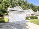 This home has a one car garage with an extended driveway and manicured lawn at 159 Misty Ridge Trl, Stockbridge, GA 30281