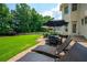 Spacious backyard with a well-maintained lawn, patio, and outdoor dining set surrounded by lush trees at 6105 Overlook Park Dr, Cumming, GA 30040