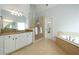 Primary bathroom with dual vanities, glass shower, and a tub at 6105 Overlook Park Dr, Cumming, GA 30040