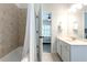Bright bathroom with tiled bathtub and shower with view into the bedroom, and a white vanity at 6105 Overlook Park Dr, Cumming, GA 30040