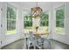 Bright breakfast nook with hardwood floors, large bay windows, and a modern light fixture at 6105 Overlook Park Dr, Cumming, GA 30040
