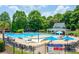 Large community pool surrounded by lounge chairs, umbrellas, and lush landscaping at 6105 Overlook Park Dr, Cumming, GA 30040