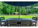 Outdoor dining with an umbrella and seating overlooking the green lawn and play structure at 6105 Overlook Park Dr, Cumming, GA 30040