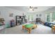 Spacious playroom with a variety of toys, built-in shelving, and ample natural light from the large windows at 6105 Overlook Park Dr, Cumming, GA 30040