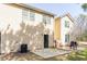 A backyard featuring a concrete patio surrounded by grass and a yellow two-story house at 7432 Battlecreek Ln, Jonesboro, GA 30236