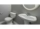 This powder room features a white pedestal sink and a toilet against a gray wall at 7432 Battlecreek Ln, Jonesboro, GA 30236