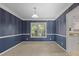 The formal dining room features chair rail, blue striped walls, new carpet and a window at 206 Five Iron Nw Ct, Kennesaw, GA 30144