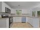Updated kitchen features stainless steel appliances, granite counters, and bright white cabinetry at 206 Five Iron Nw Ct, Kennesaw, GA 30144