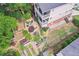 Aerial view of a backyard featuring tiered gardens, a stone patio with seating, and lush greenery surrounding the property at 218 South Se Ave, Atlanta, GA 30315