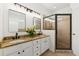Granite counters and a black framed shower accent this bathroom's double vanity and custom lighting at 218 South Se Ave, Atlanta, GA 30315