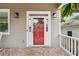 Close-up of a red front door with sidelights, brick-lined porch, and hanging ferns at 218 South Se Ave, Atlanta, GA 30315