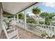 View of a covered front porch featuring brick flooring, hanging plants, and comfortable seating at 218 South Se Ave, Atlanta, GA 30315
