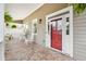 Charming front porch with brick flooring, white rocking chairs, a red door, and hanging plants at 218 South Se Ave, Atlanta, GA 30315