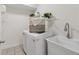 A bright laundry room with shelving above the washer and utility sink at 218 South Se Ave, Atlanta, GA 30315