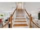 Elegant staircase with hardwood steps and white railings, leading to the upper level with an abundance of natural light at 218 South Se Ave, Atlanta, GA 30315