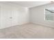 Neutral bedroom with carpeted floor, a window with blinds, and a double door closet at 4036 Trimrose Ct, Atlanta, GA 30349