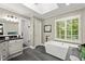 Bright bathroom with modern tub, walk-in shower, dark floors, and natural light from a window with shutters at 4246 N Mountain Ne Rd, Marietta, GA 30066