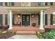 Close up of front porch with black metal door, stately white columns, and brickwork at 4246 N Mountain Ne Rd, Marietta, GA 30066