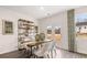 Bright dining room featuring a wooden table, modern chairs, decorative shelving, and natural light from a sliding glass door at 11408 Gray Branch Dr, Lawrenceville, GA 30045