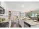 Open kitchen design with white cabinets, granite countertops, dining area, and stainless appliances at 11408 Gray Branch Dr, Lawrenceville, GA 30045