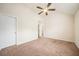 A spacious bedroom features plush carpet, a ceiling fan, and access to other areas of the home at 212 Jetta Cir, Mcdonough, GA 30253