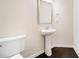 Elegant half bathroom features a stylish pedestal sink and hardwood flooring, creating a chic space at 212 Jetta Cir, Mcdonough, GA 30253
