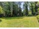 Spacious backyard with well-maintained lawn and manicured shrubs offers a peaceful outdoor retreat at 4220 Singing Post Ne Ln, Roswell, GA 30075
