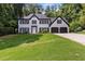 Traditional two-story house with brick facade, black shutters, a well manicured lawn and a two car garage at 4220 Singing Post Ne Ln, Roswell, GA 30075