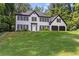 Traditional two-story house with brick facade, black shutters, a well manicured lawn and a two car garage at 4220 Singing Post Ne Ln, Roswell, GA 30075