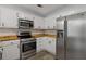 Well-equipped kitchen featuring stainless steel appliances, ample white cabinets, and butcher block countertops at 4220 Singing Post Ne Ln, Roswell, GA 30075