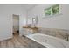 Bright main bathroom featuring double sinks, soaking tub, and bright natural light at 4220 Singing Post Ne Ln, Roswell, GA 30075