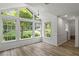 Sunroom with large windows offering scenic views and hardwood floors at 4220 Singing Post Ne Ln, Roswell, GA 30075