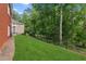 Beautiful backyard boasts lush green grass, mature trees, and privacy fencing at 952 Moores Walk Ln, Suwanee, GA 30024