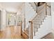 Bright foyer with hardwood floors, chandelier, and a staircase featuring elegant white railings and wooden banisters at 952 Moores Walk Ln, Suwanee, GA 30024